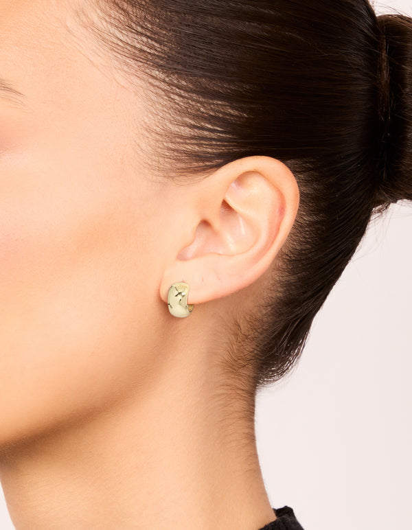 Design spotlight on small round open hoop earrings in a 3-pack with mixed metal plated finish featuring gold and silver tones on ear view