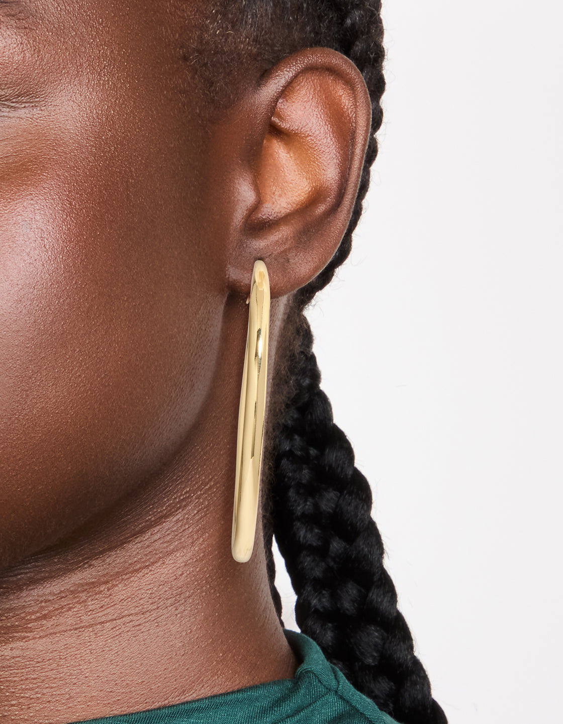 Featuring gold plated large hoop earrings with closure in gold on ear view