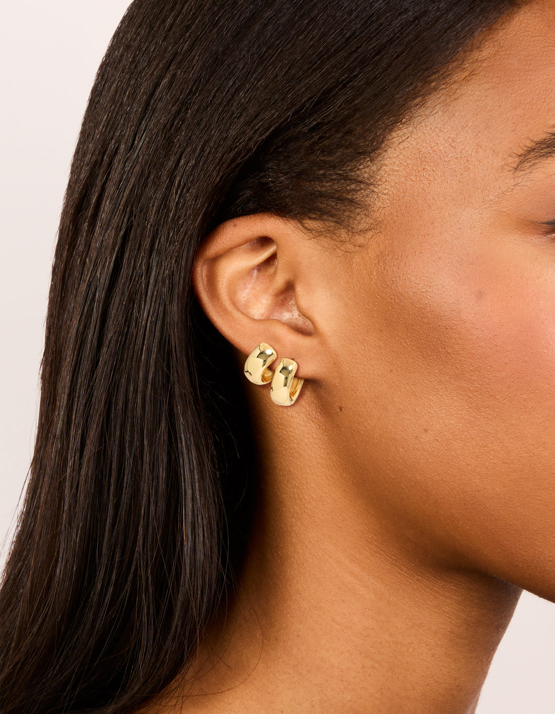 Featuring gold plated huggie earrings 2-pack on ear view