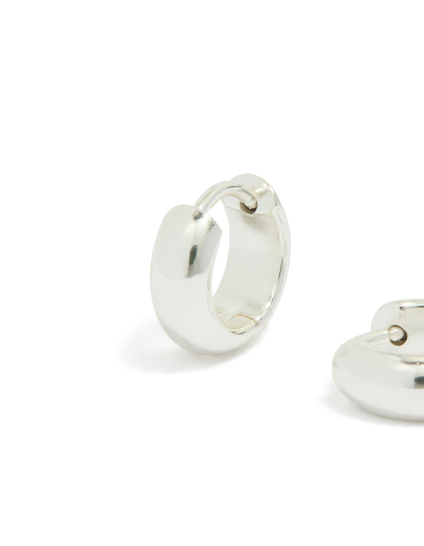 Featuring chunky waterproof huggie earrings in silver plated stainless steel close up view