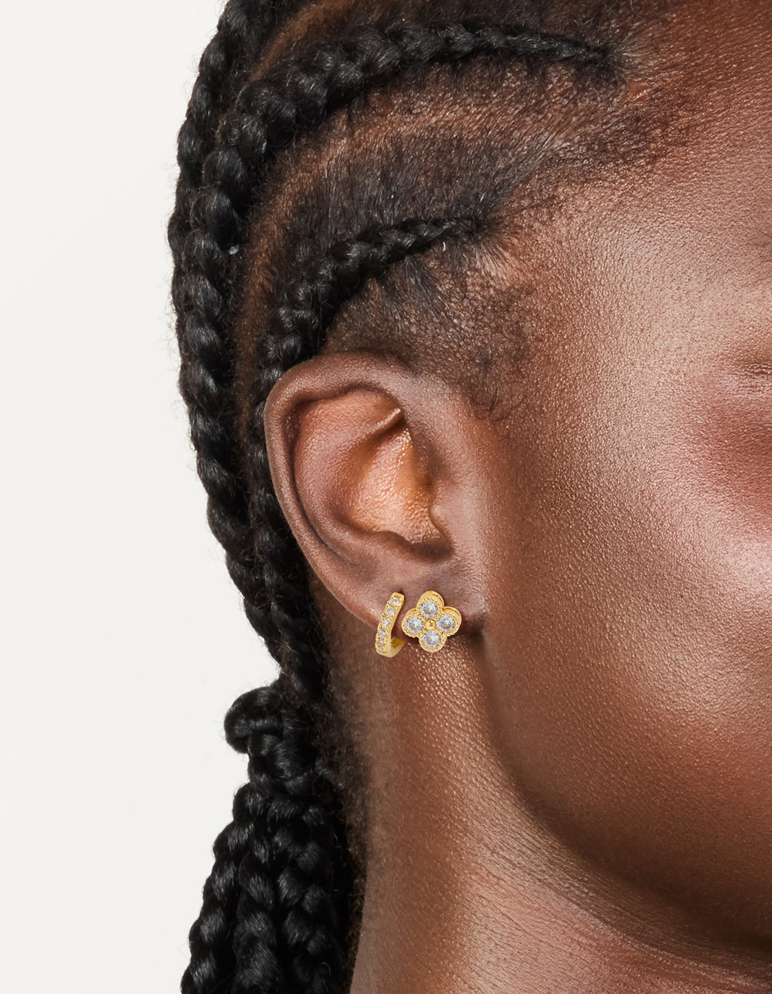 Featuring floral gold plated cubic zirconia huggie earrings in a 2-pack on ear view