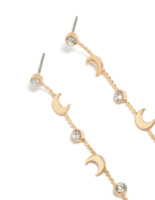 Featuring gold clear diamante and celestial charm thin drop earrings close up view