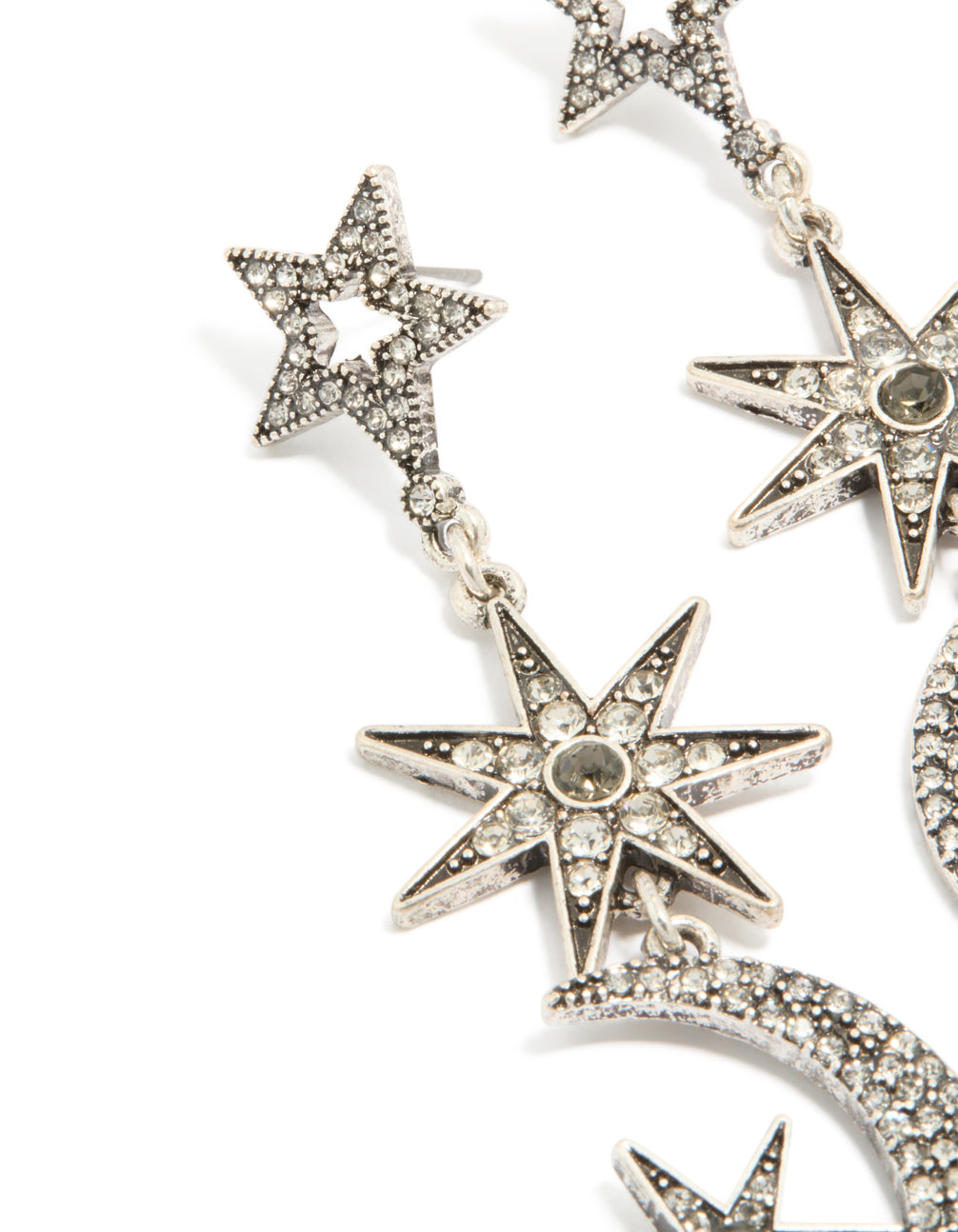 Detailed view of dainty celestial drop earrings with moon and star design in silver close up view