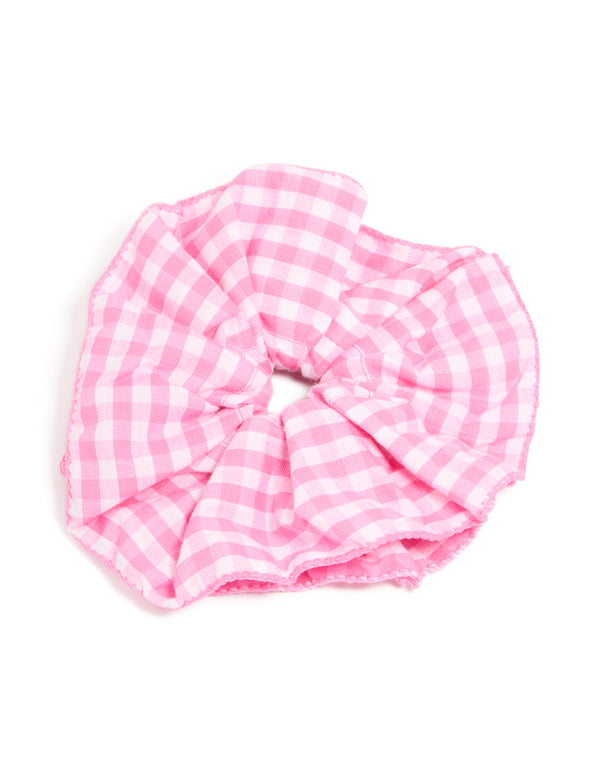 Crafted from checkered fabric, this ruffled scrunchie in pink and white front view