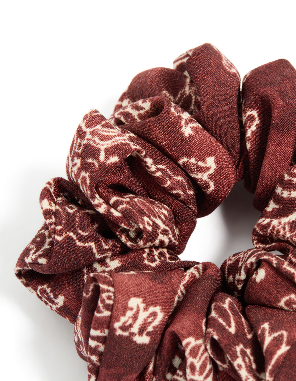 Crafted statement fabric scrunchie features paisley design in maroon beige tones side view