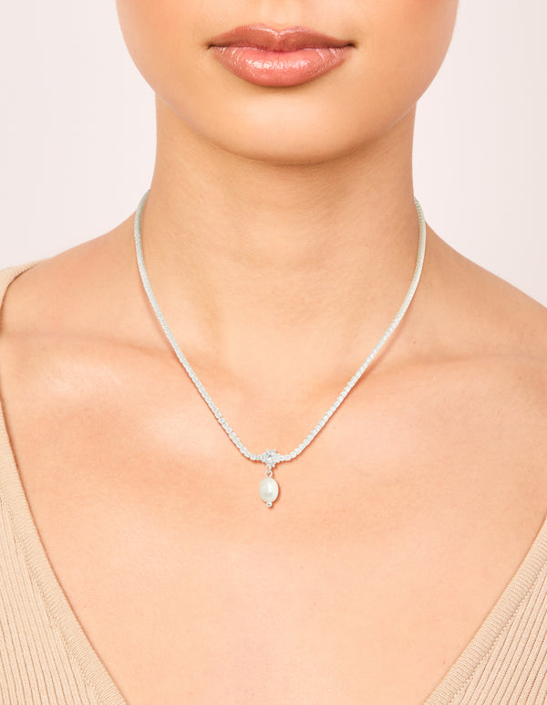 Showcasing a silver plated cubic zirconia and freshwater pearl tennis necklace with on neck view