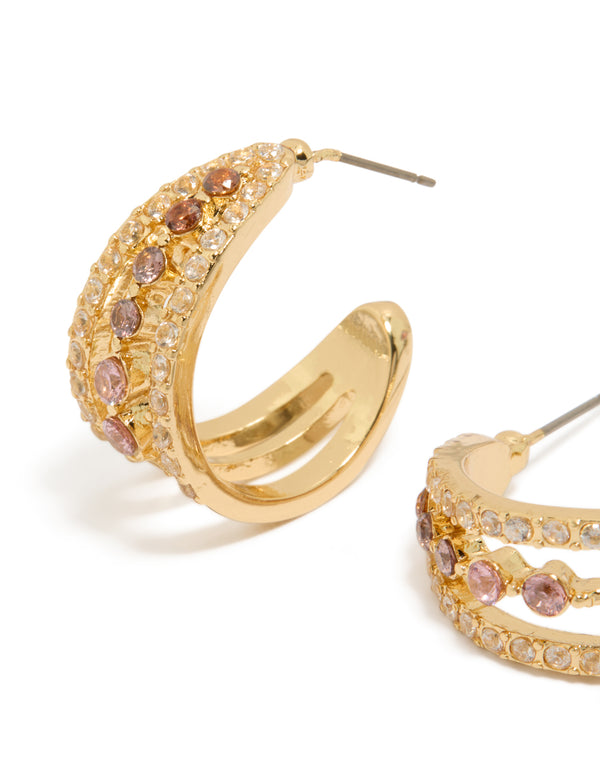 Featuring gold plated cubic zirconia triple hoop medium earrings with intricate stone settings close up view