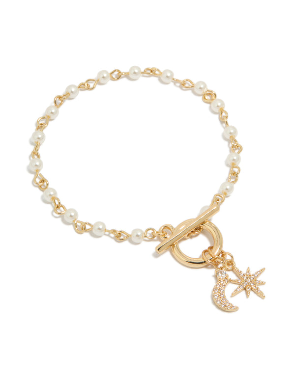 Showcasing a gold plated pearl and cubic zirconia bracelet featuring celestial star moon charm fob front view