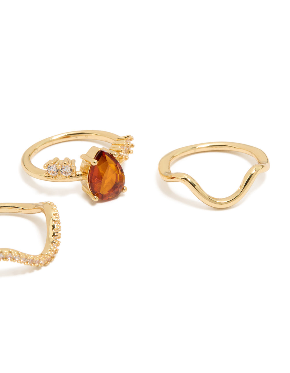 Presenting gold plated red cubic zirconia teardrop and wavy rings in a statement 3-pack with crystal embellishments side detail view
