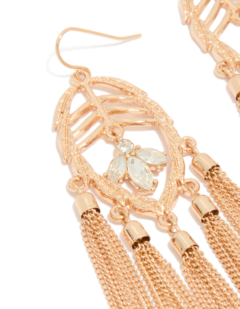 Highlighting statement charm tassel drop earrings in gold with leaf and clear diamante details close up view