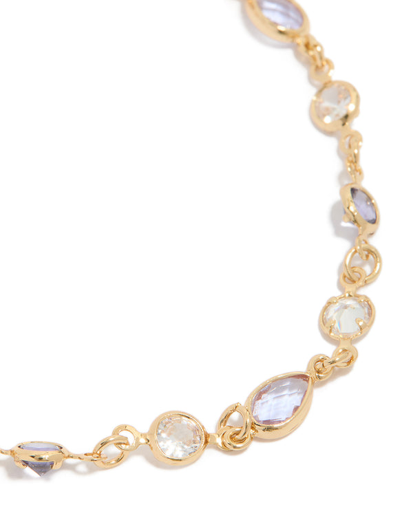Showcasing a gold plated charm bracelet with purple and clear cubic zirconia in circle bezel settings close up view