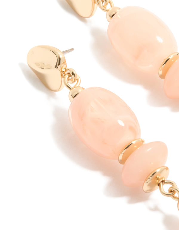 Showcasing oval cut pink beaded statement drop earrings in gold close up view