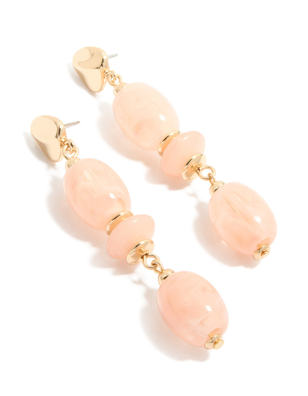 Statement drop earrings featuring oval cut pink beads with gold accents front view