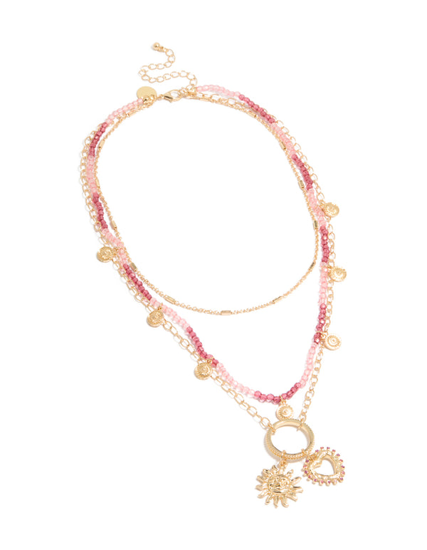 Discover a gold pink beaded and celestial layered necklace with charm featuring sun and heart in a statement design front view
