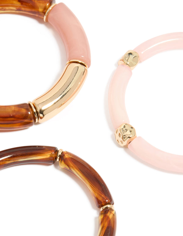 Featuring a beaded charm stretch bracelet 3-pack crafted from resin in pink and gold close up view