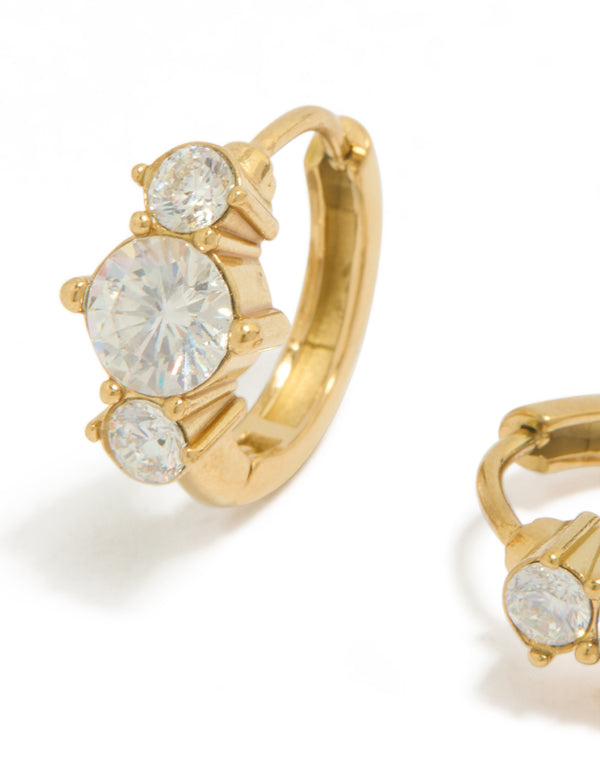Featuring mini trio cubic zirconia huggie earrings in waterproof gold plated stainless steel with dainty styling close up view