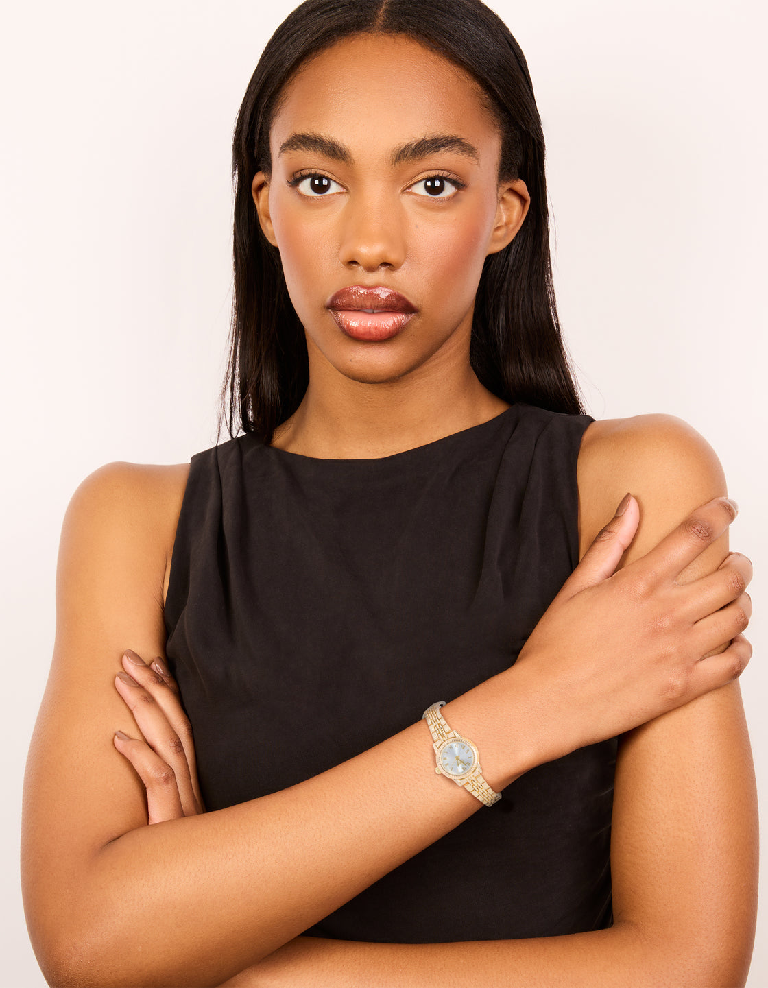 Showcasing a gold plated mini round watch with white dial showcasing roman numerals, women's formal analog timepiece with link-band strap and statement styling on model view