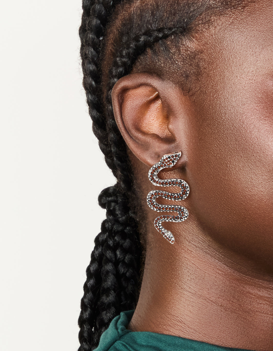 These statement snake earrings feature silver with orange diamante detailing on ear view