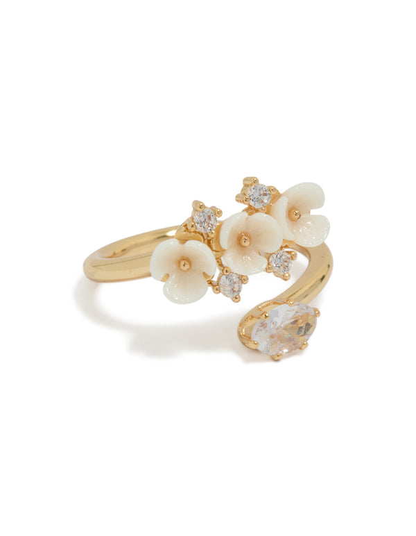 This statement ring showcases a gold plated wrap design featuring delicate floral with ivory petals and crystal accents front view