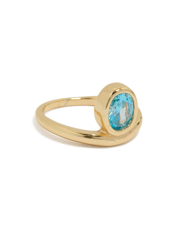 Discover this gold plated stainless steel statement ring featuring an oval blue cubic zirconia crystal front view