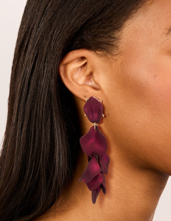 Showcasing burgundy coated metal petal drop earrings statement style in maroon and gold on ear view