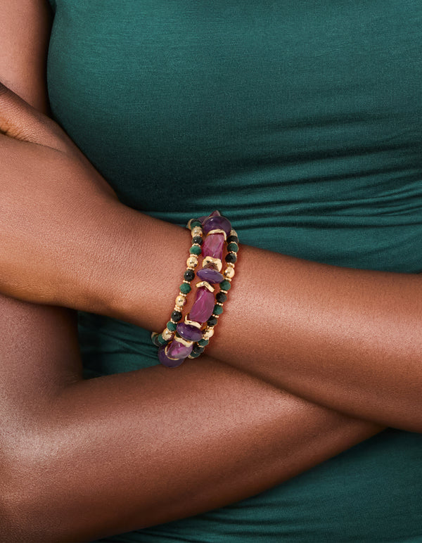 Crafted from beads and balls these chunky mixed stretch bracelets in a 3-pack showcase dark magenta, gold, green, and black tones on wrist view