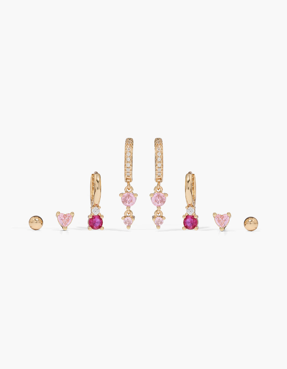Showcasing a gold light and hot pink cubic zirconia earrings 4-pack featuring heart and charm, huggie and stud closures front view
