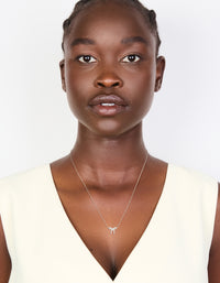 Presenting a sterling silver cubic zirconia bow pendant necklace with dainty on model view - link has visual effect only