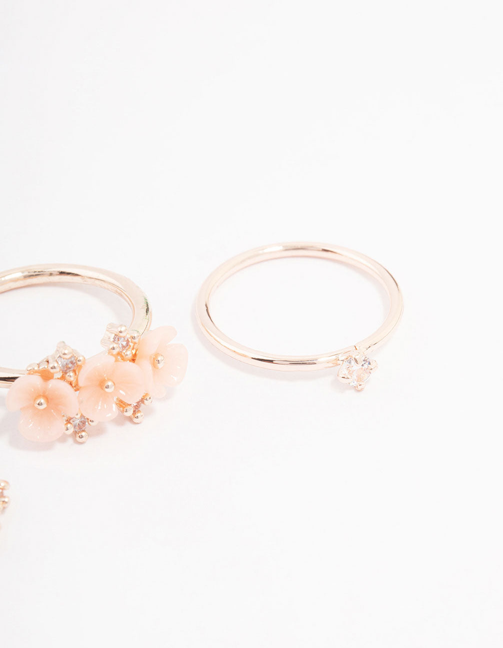 Featuring rose gold plated triple flower stacking ring pack in dainty style close up view