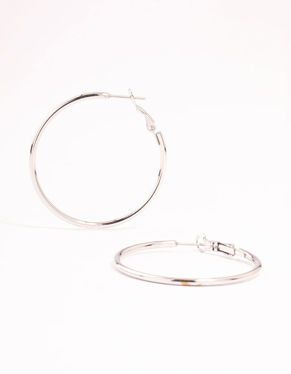 Showcasing surgical steel thin hoop earrings in silver with hoop closure front view