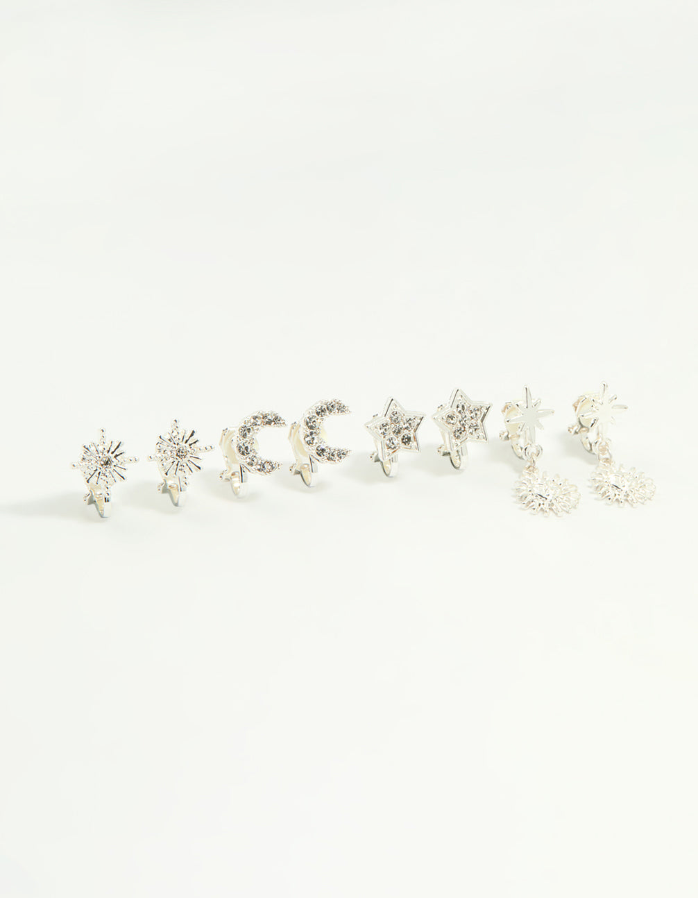 Showcasing silver star and moon clip-on earrings 4-pack featuring celestial designs in clear front view