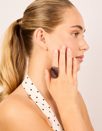 Showcasing a dark brown acrylic large obtuse ring in chunky statement style on finger view - link has visual effect only