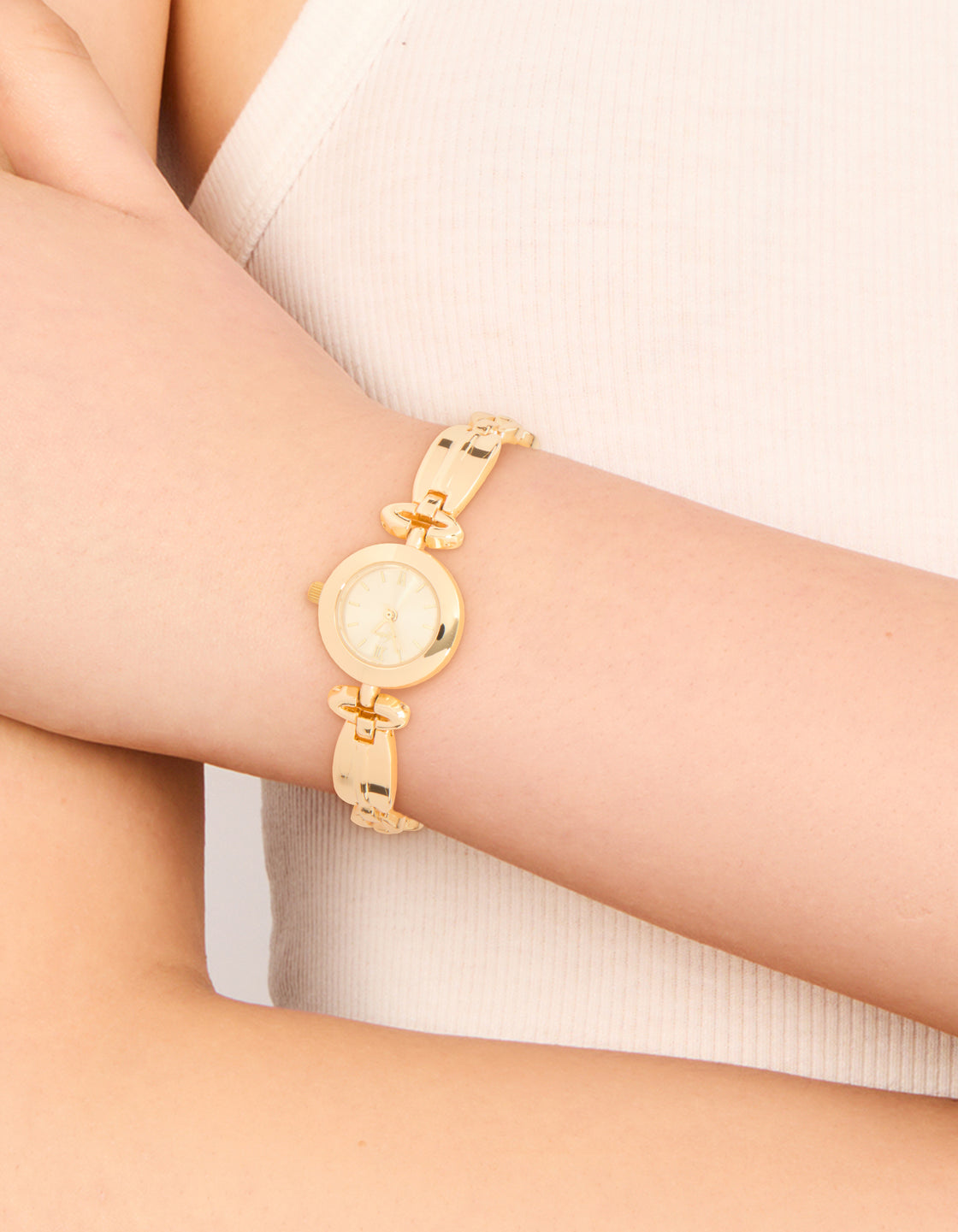 Featuring a gold small diamante vintage watch with white dial displaying roman numerals, round shape, link band strap crafted for women's casual occasions, analog timepiece on wrist view