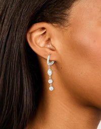 Elegant waterproof stainless steel cubic zirconia huggie drop earrings in silver and clear stone on ear view - link has visual effect only