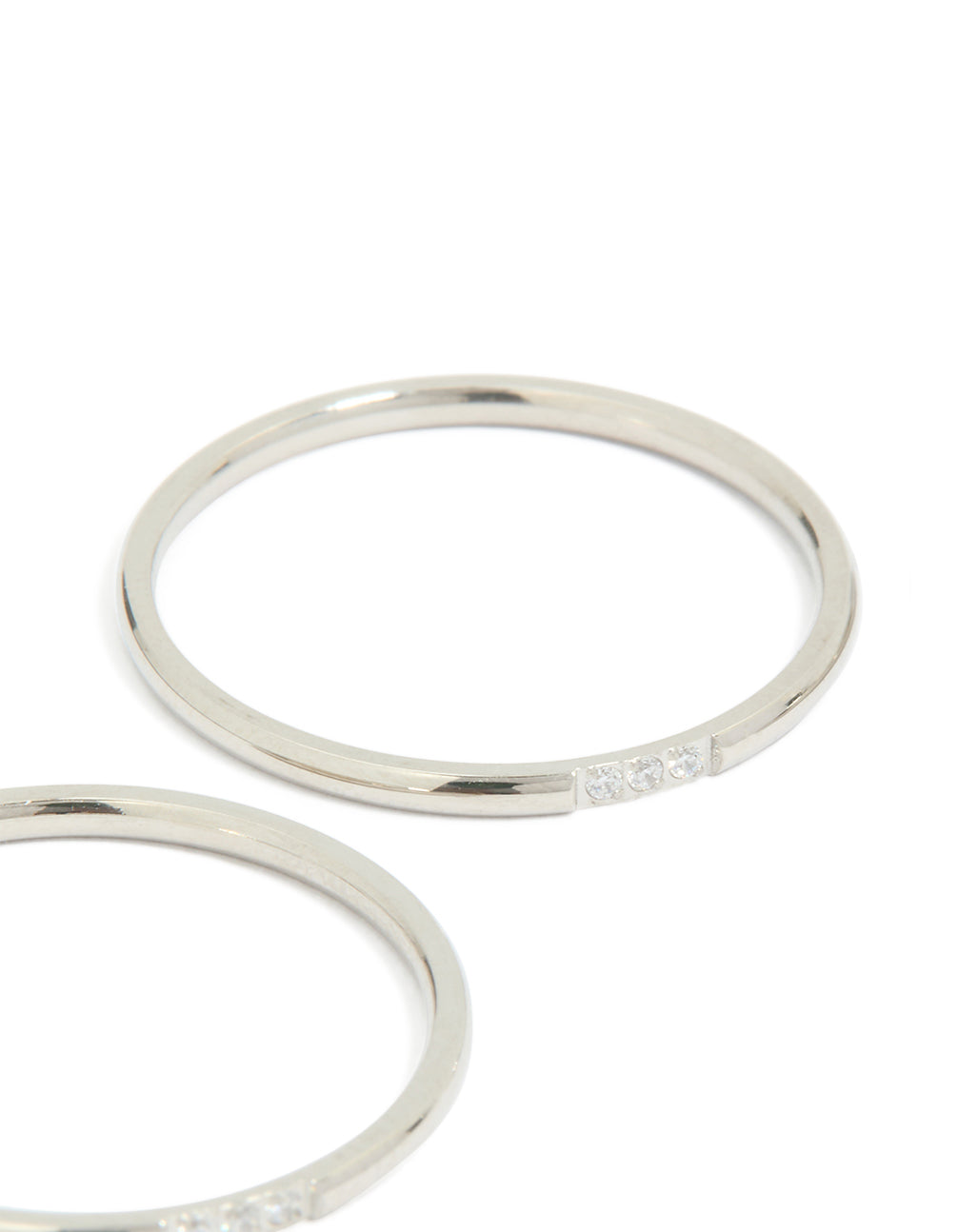 Showcasing waterproof stainless steel construction, this thin cubic zirconia trio rings 3-pack in silver and clear stone close up view