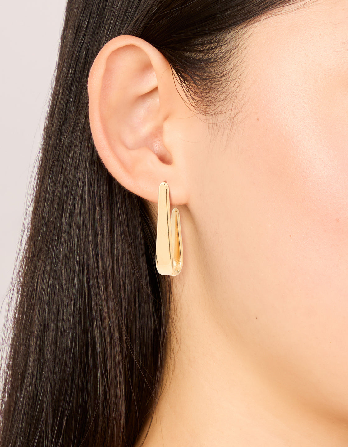 Featuring waterproof gold plated stainless steel long drop hoop earrings with closure on ear view