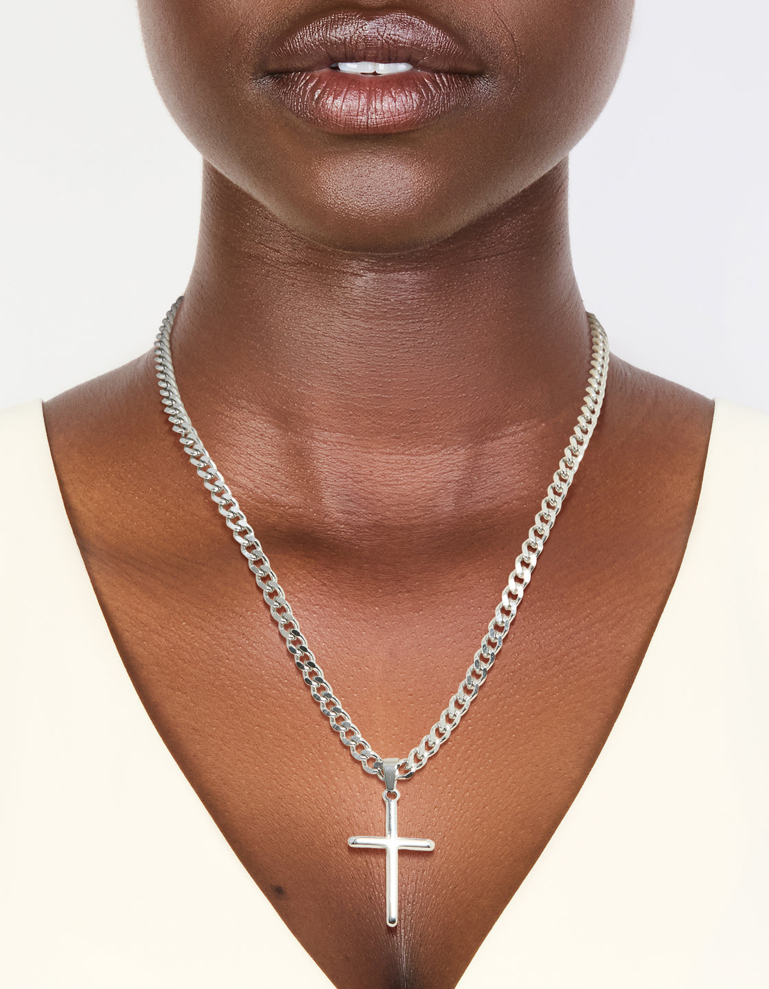 Showcasing a waterproof stainless steel smooth plain necklace featuring a cross pendant in silver on neck view