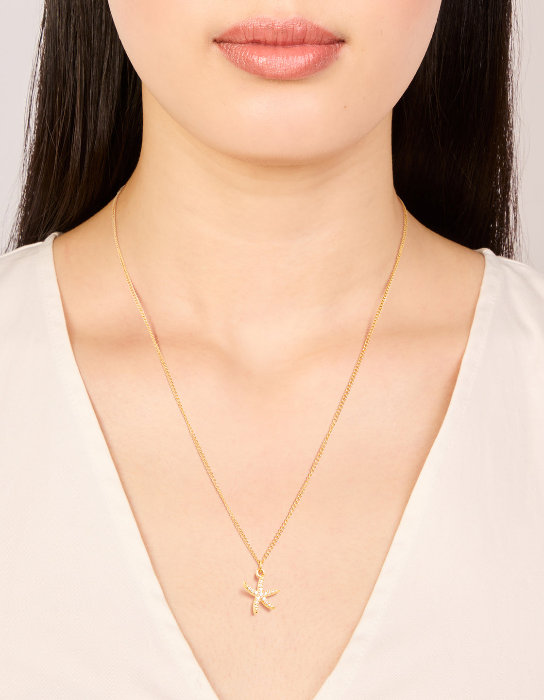 Featuring waterproof gold plated stainless steel cubic zirconia pavé starfish pendant necklace with ocean theme on neck view