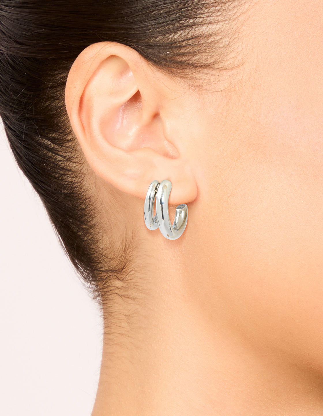 Featuring waterproof stainless steel double illusion open hoop earrings in chunky silver on ear view
