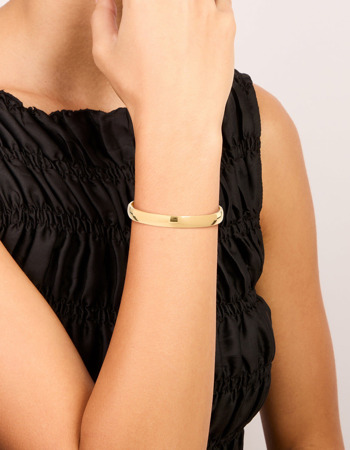 Crafted from waterproof rose gold plated stainless steel, this smooth hinged bangle is shown on wrist view