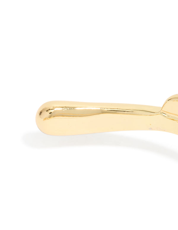 Highlighting the polished finish of gold plated organic open wave wrist cuff closure detail view