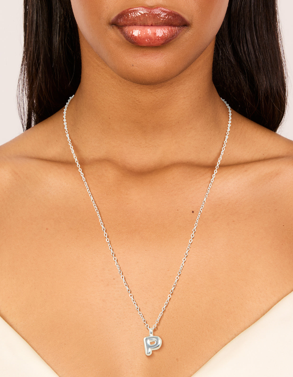 Featuring a waterproof stainless steel mini bubble letter P necklace with pendant and initial detail in dainty silver on neck view