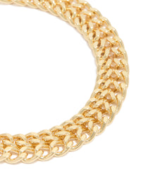 Highlighting the double flat curb chain bracelet with gold plated finish and textured link detail close up view - link has visual effect only