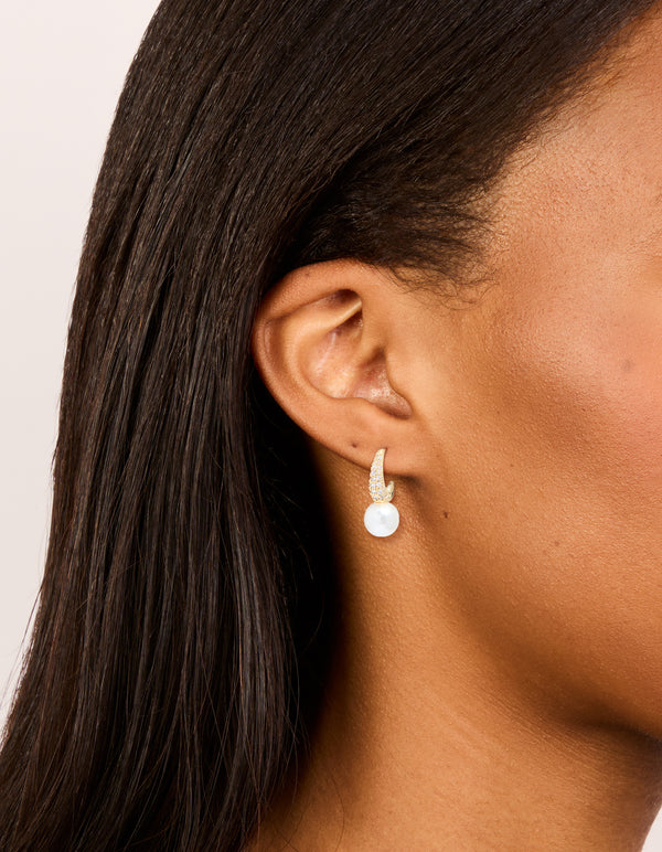 Showcasing gold plated cubic zirconia and pearl small pave open hoop earrings on ear view