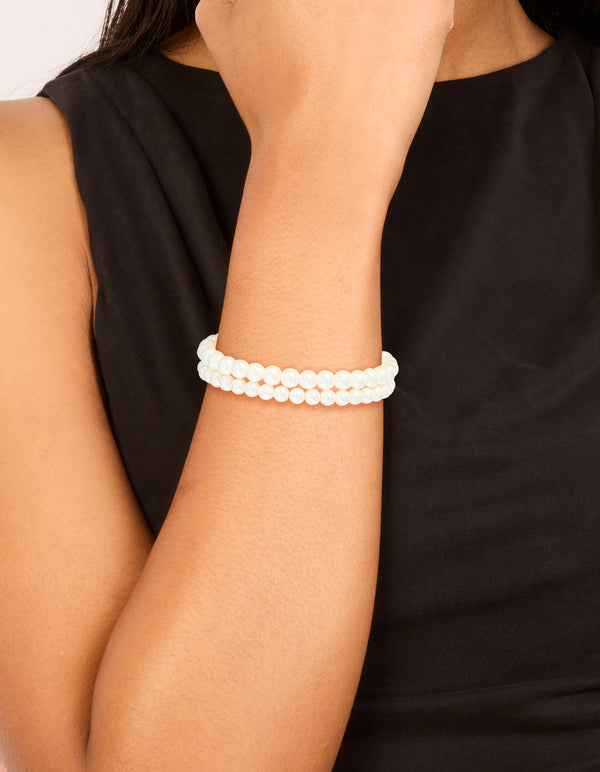 Showcasing Gold Plated Classic Pearl Bracelets 2-Pack accents in white and gold on wrist view