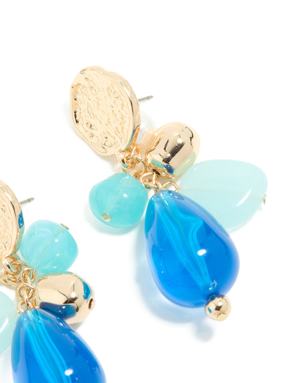 Highlighting gold textured and blue beaded drop earrings with coin in statement style post detail view