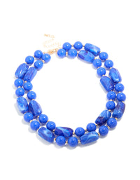 Featuring a dark blue acrylic beaded long layered necklace with balls and statement style in royal and dodger blue with gold accents front view - link has visual effect only