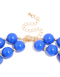 Displaying a dark blue acrylic beaded long layered necklace with balls and statement style in royal and dodger blue with gold accents clasp detail view - link has visual effect only