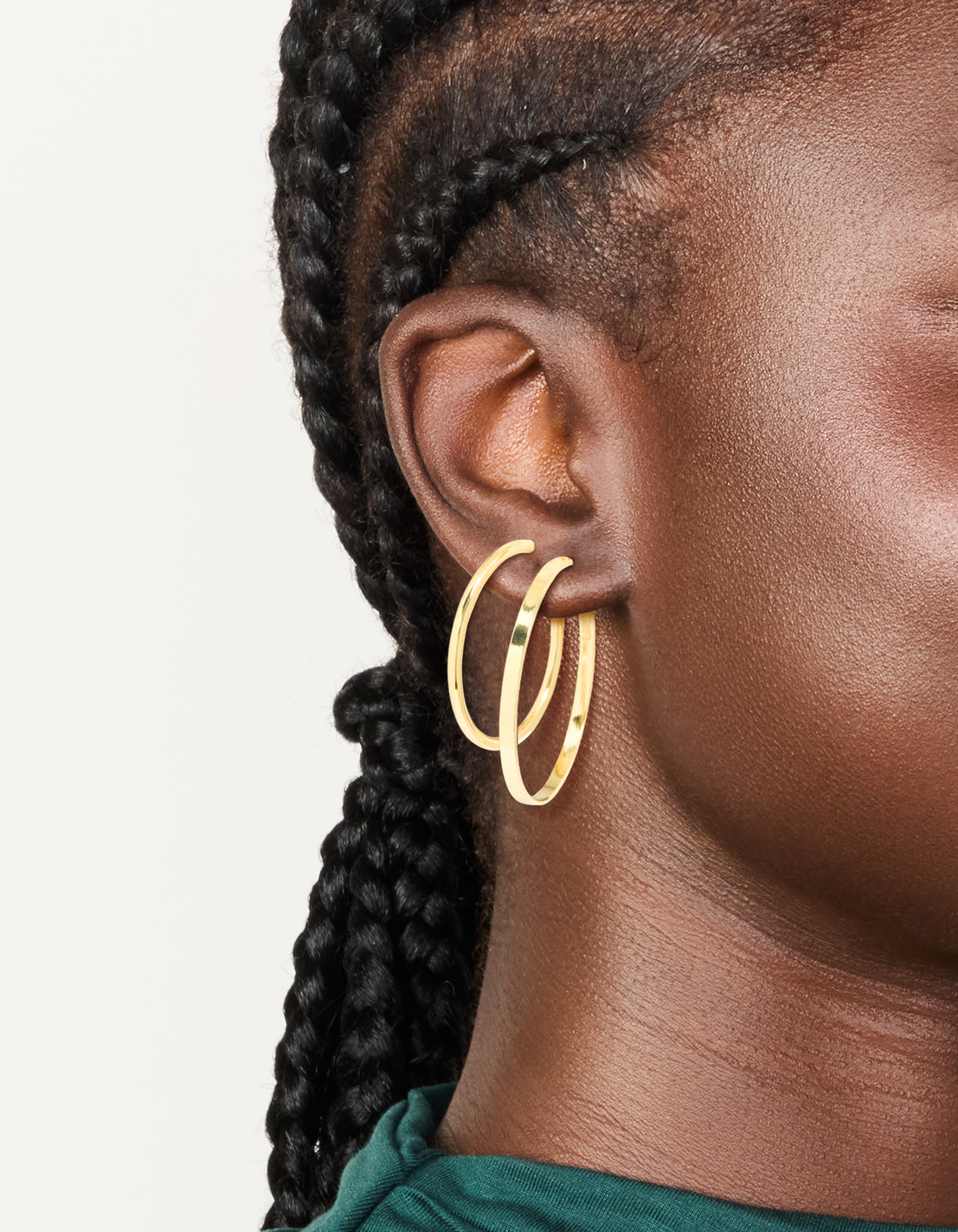 Showcasing thick flat hoop earrings in a 2-pack, crafted from gold plated material with a chunky design on ear view