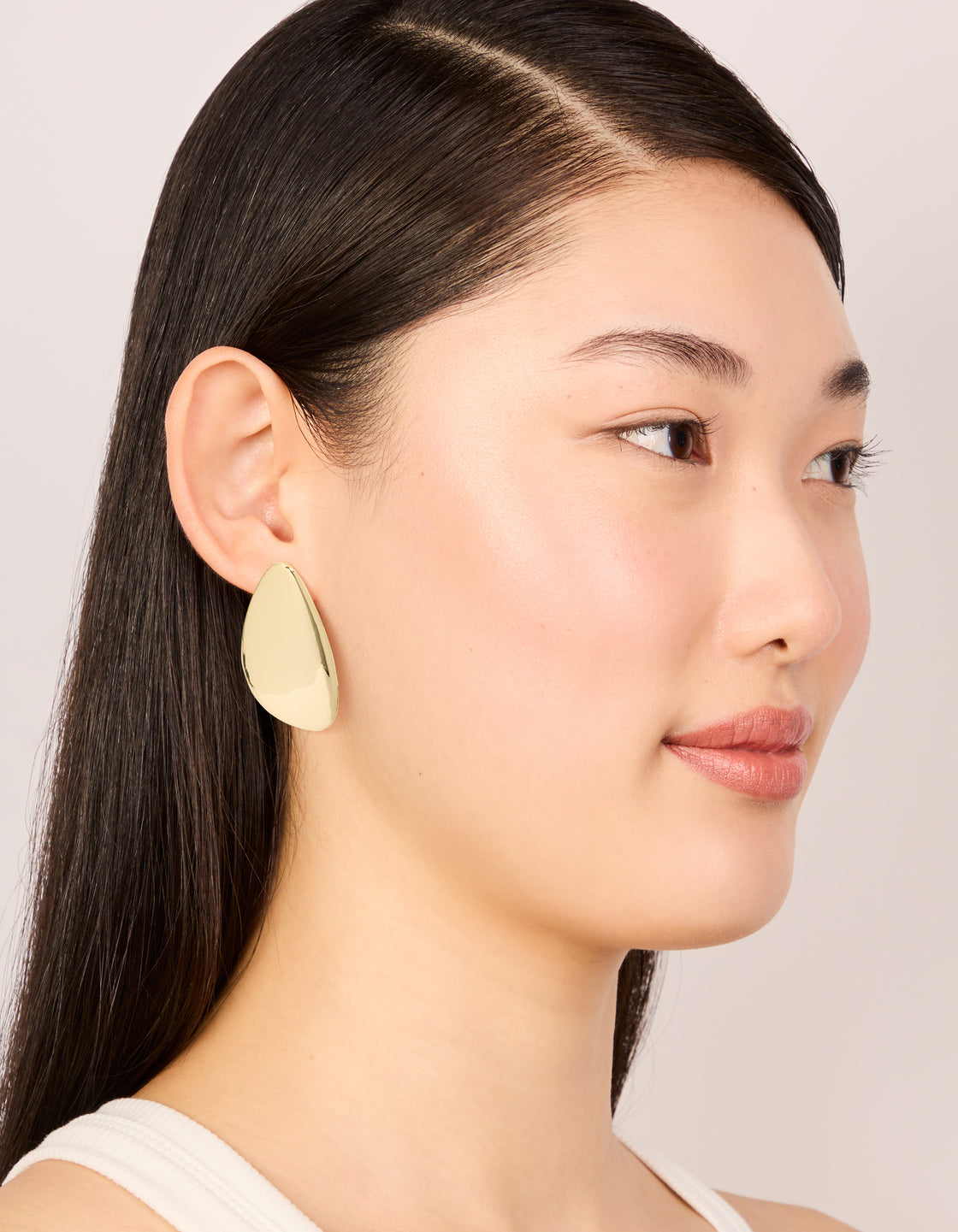 Featuring gold plated organic teardrop statement earrings on model view